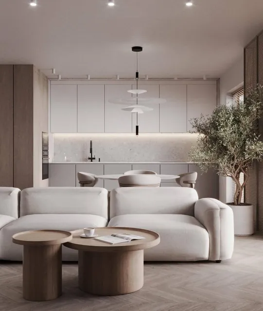Neutral living room with curved seating, timber coffee tables and an open kitchen by Celestia Architects